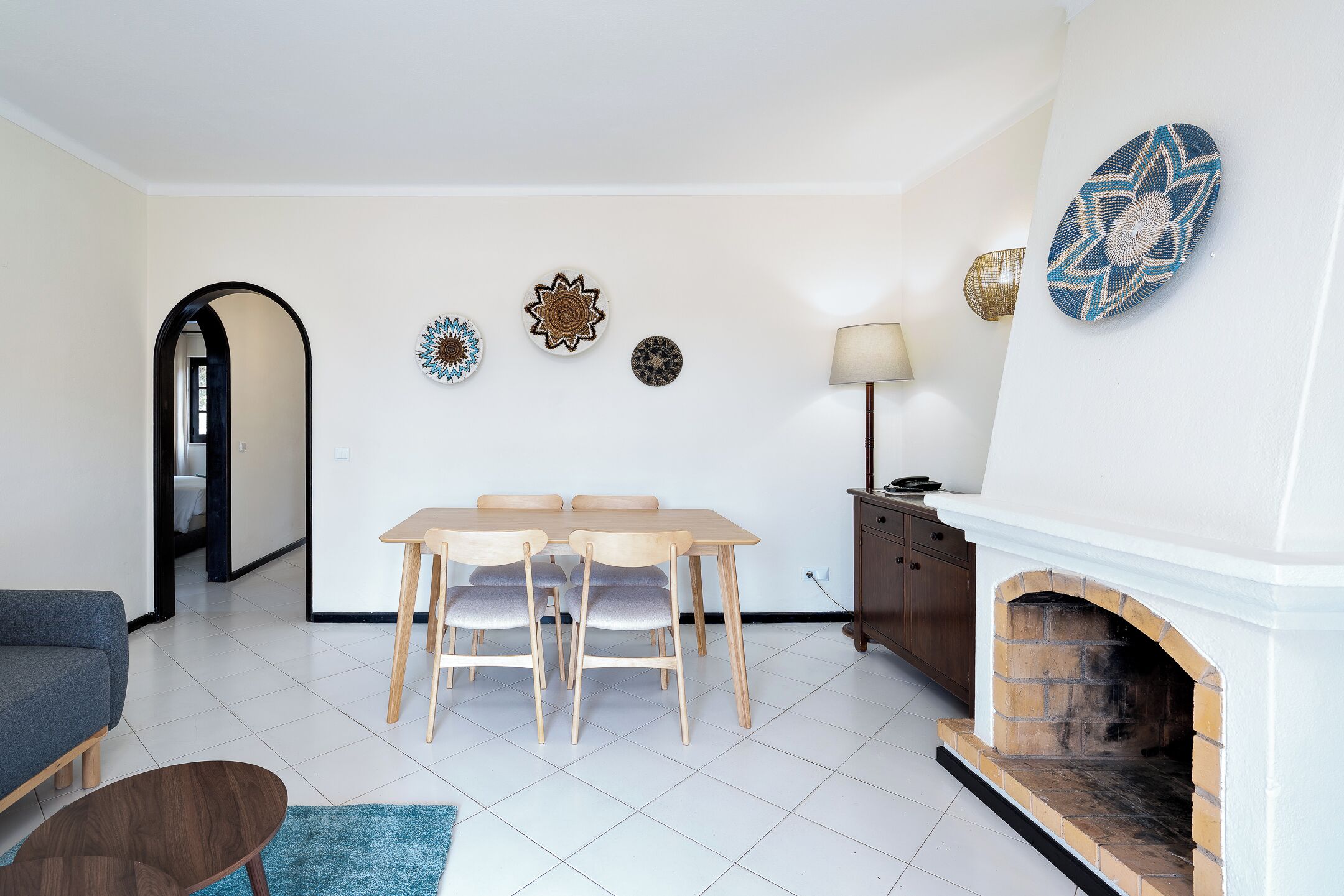 A dining area with a table and chairs, a fireplace, and decorative wall art.