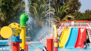 Een waterpark met een zwembad, glijbanen en fonteinen.