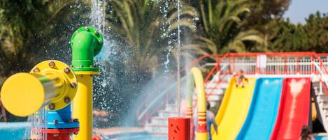 A water park with a pool, slides, and water jets.