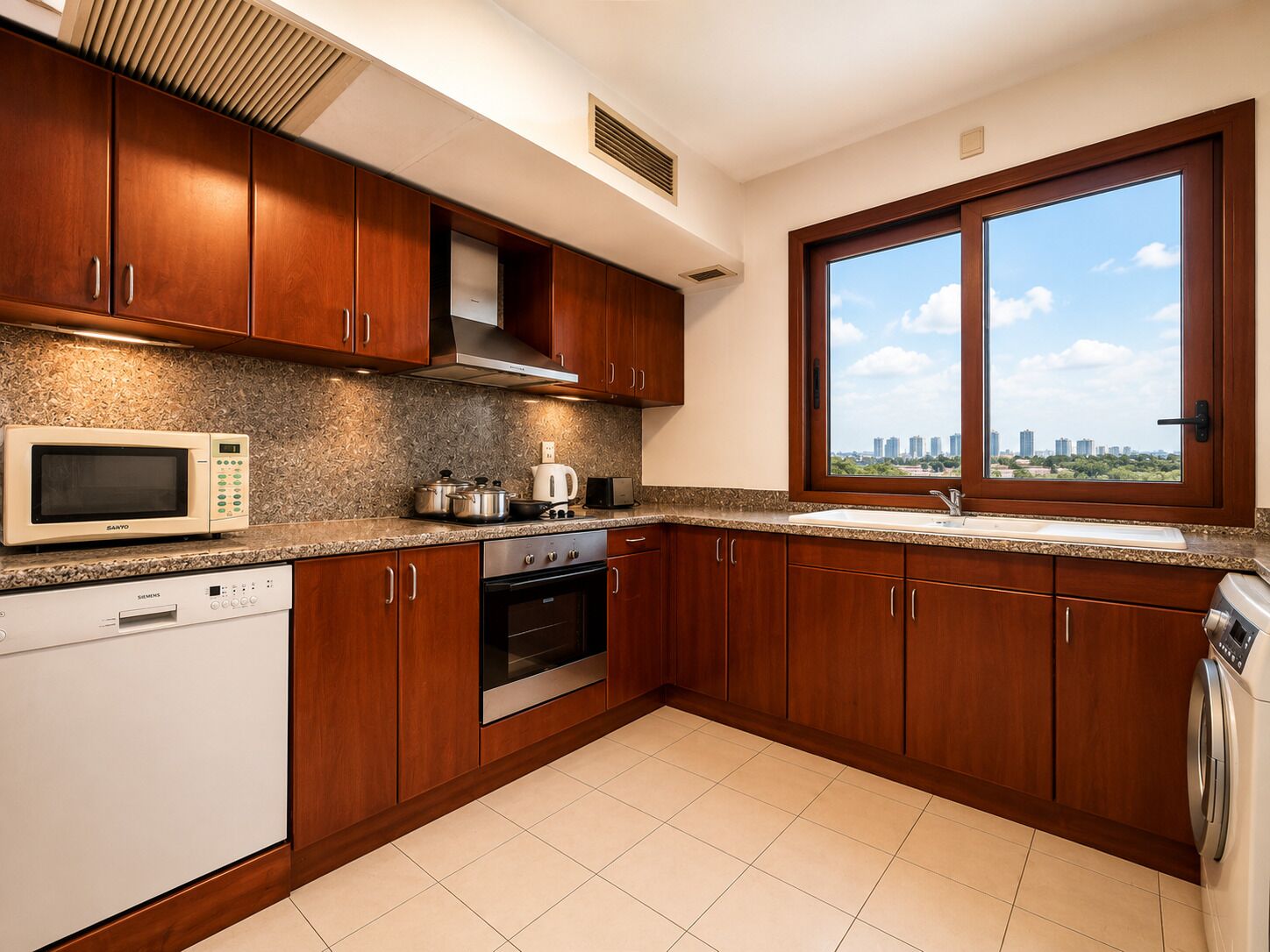 Una cocina moderna con armarios de madera, electrodomésticos de acero inoxidable y un ventanal con vistas a la ciudad.