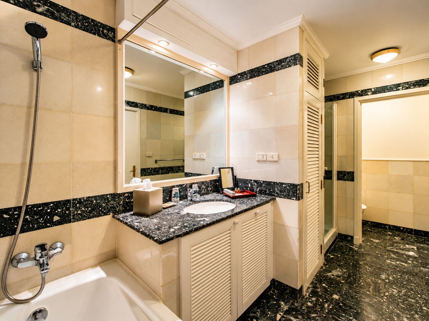A bathroom with a bathtub, a sink, a mirror, and a shower.