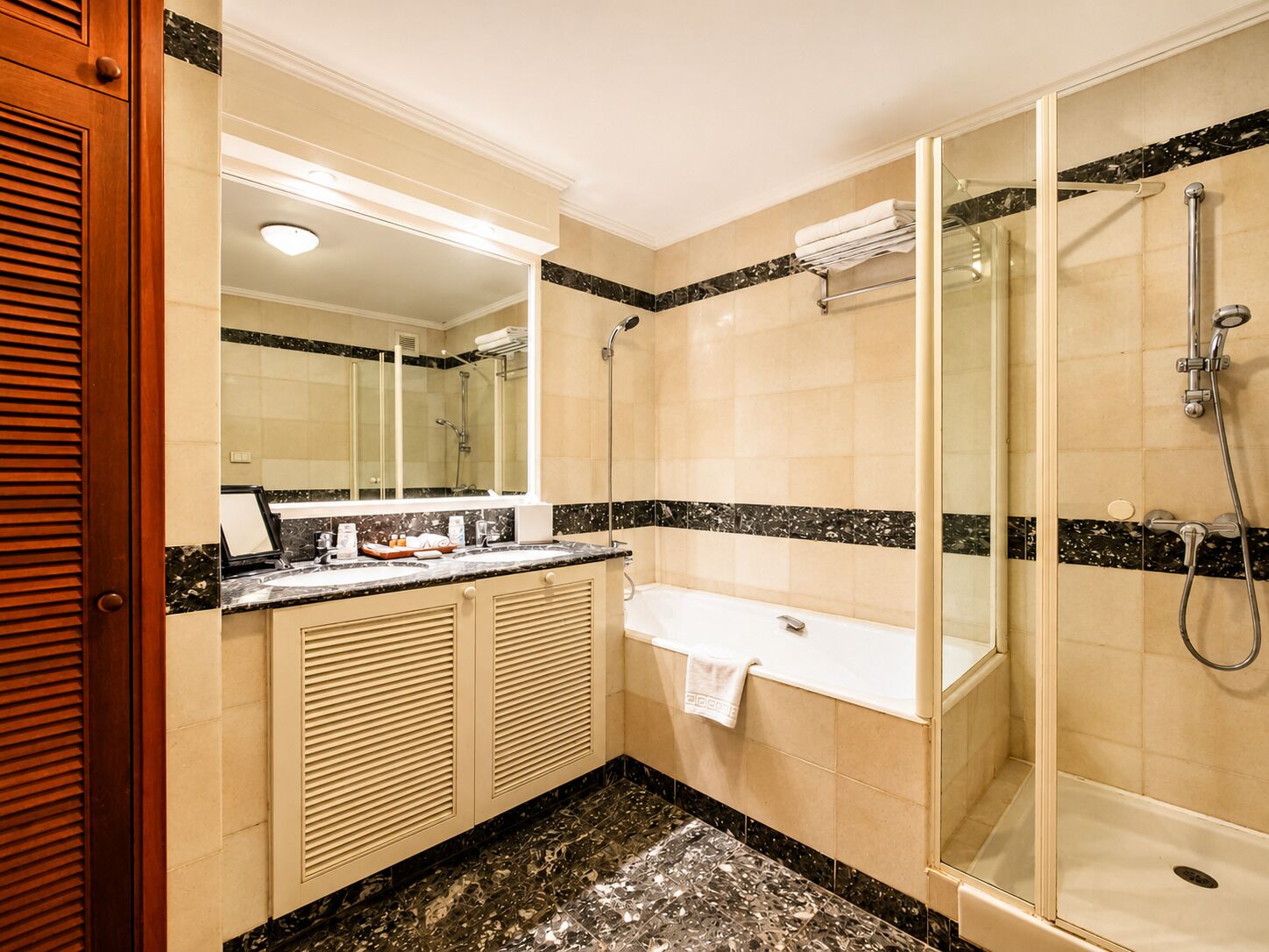 A bathroom with a bathtub, a shower, a vanity with a mirror, and a toilet.