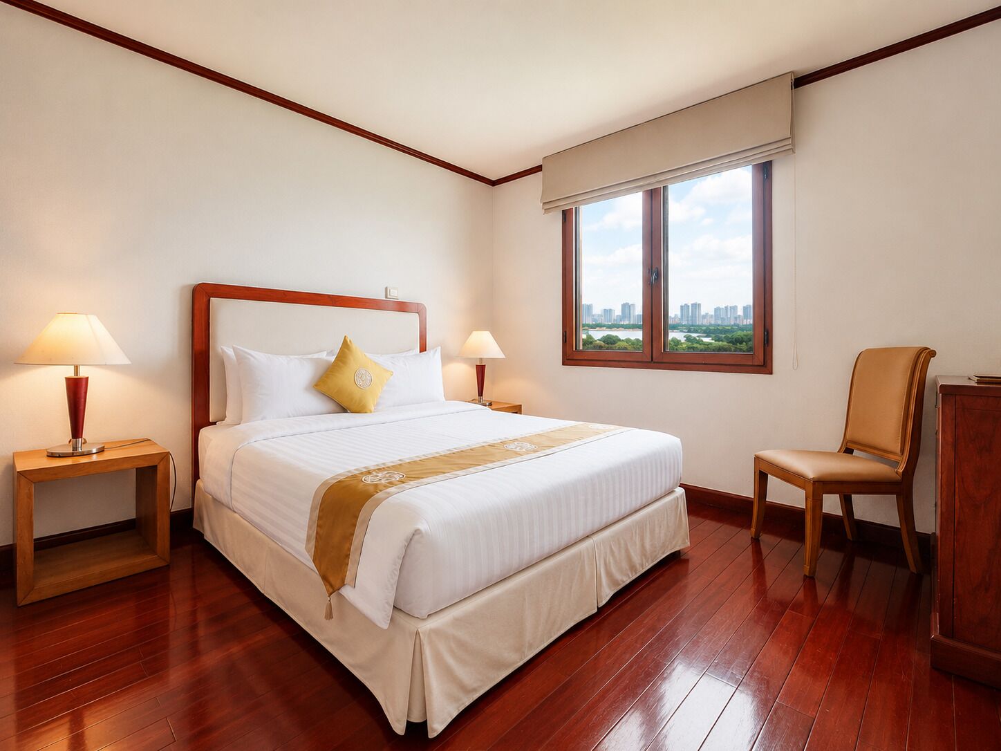 Una camera d'albergo con un letto grande, due abat-jour, una sedia, una finestra con vista sulla città e un pavimento in legno.
