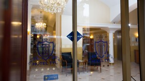 A hotel entrance with a chandelier, a check-in counter, and a reception area. - Hotel Tyl (Prague)