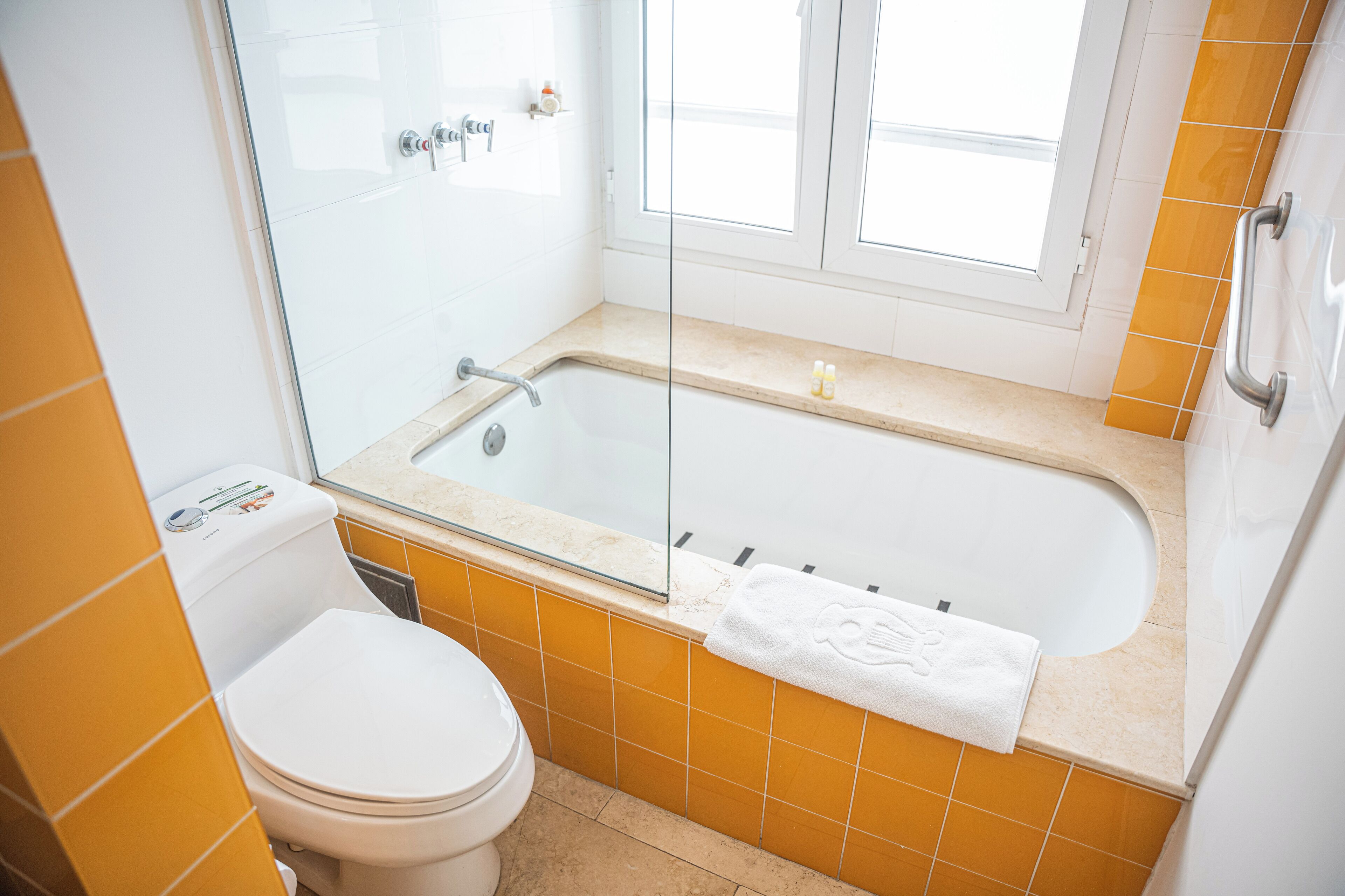 Un baño con bañera, inodoro y cabina de ducha acristalada.