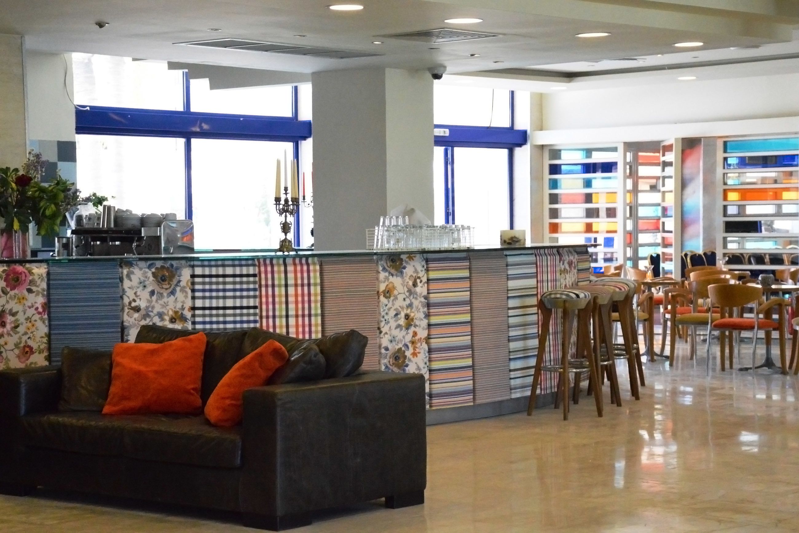 A modern interior with a sofa, chairs, a counter, and a bookshelf.
