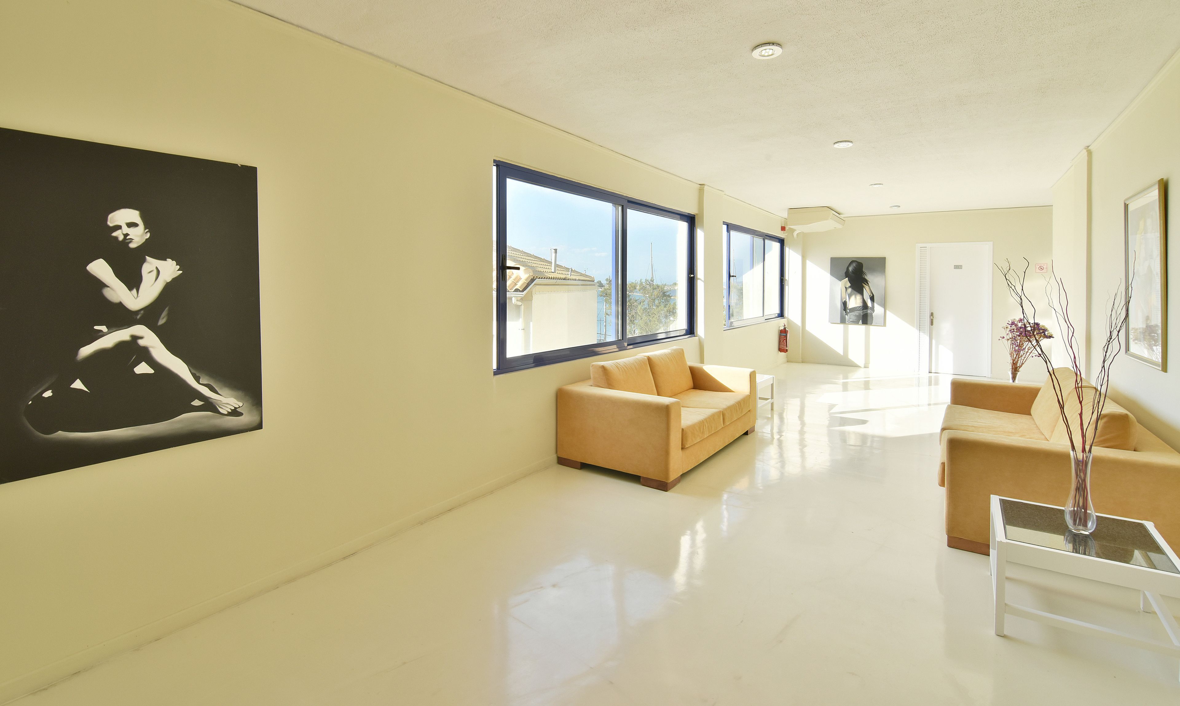 Amplia sala de estar con ventanas grandes, un sofá color beige y un diseño minimalista.