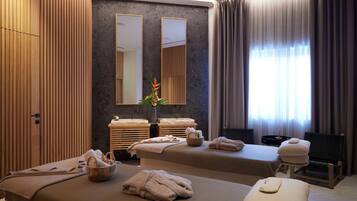 Two beds, a side table, and a large mirror in a stylish room with a textured pattern.