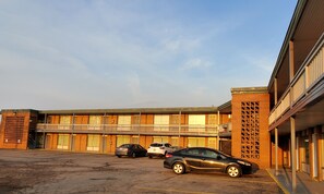 A building with a parking lot and several cars parked in front. - Royal Motel (Hermitage)