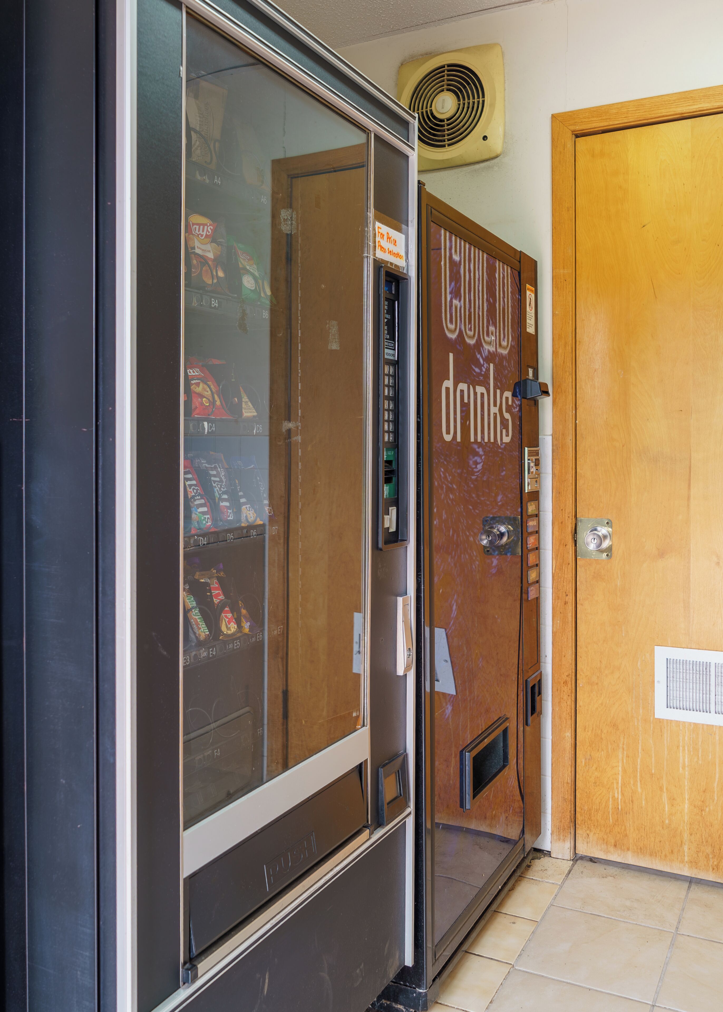 A vending machine with a sign for 'Cool Drinks' and a door with a similar sign.