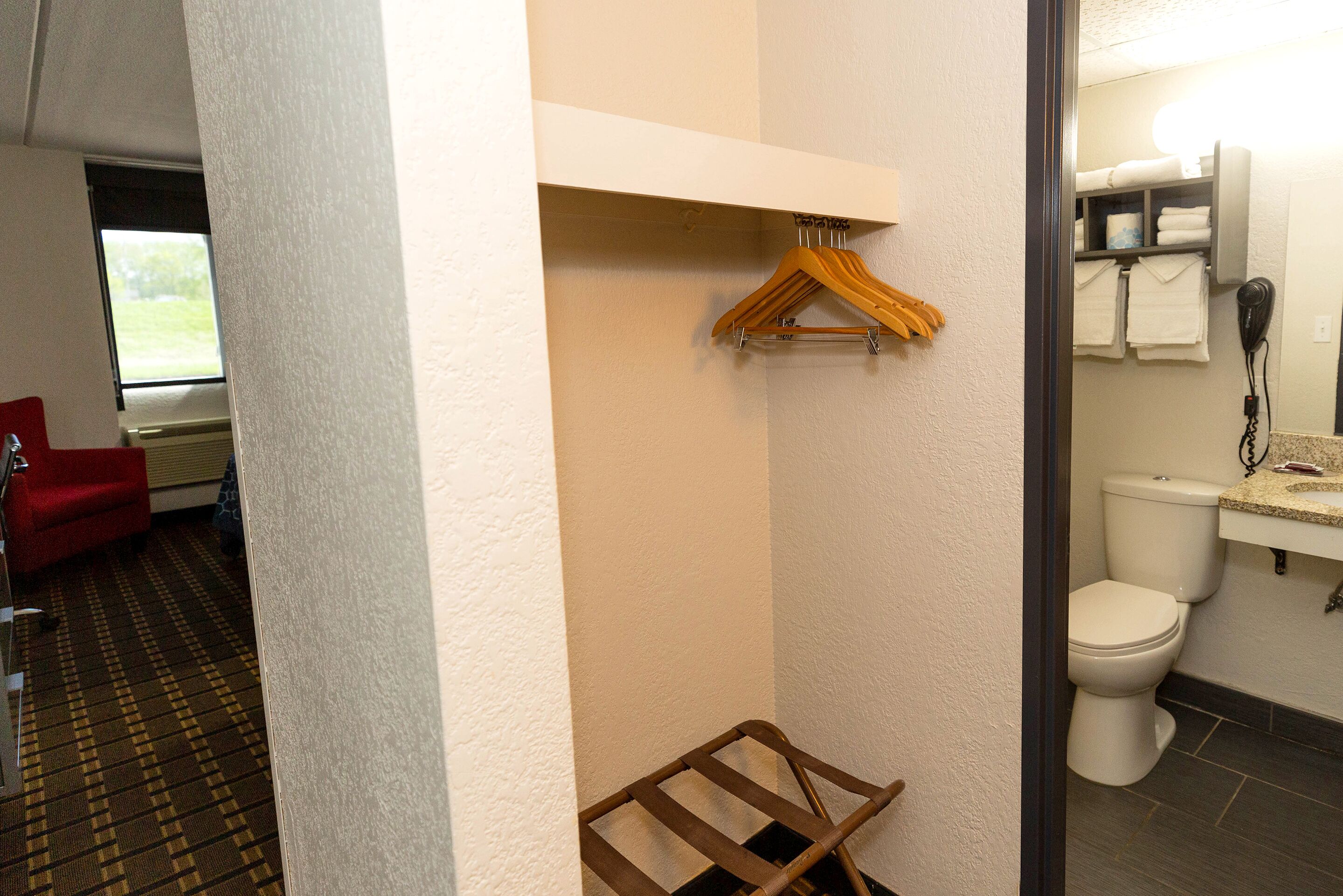 Un baño de hotel con inodoro, toallero y perchero.