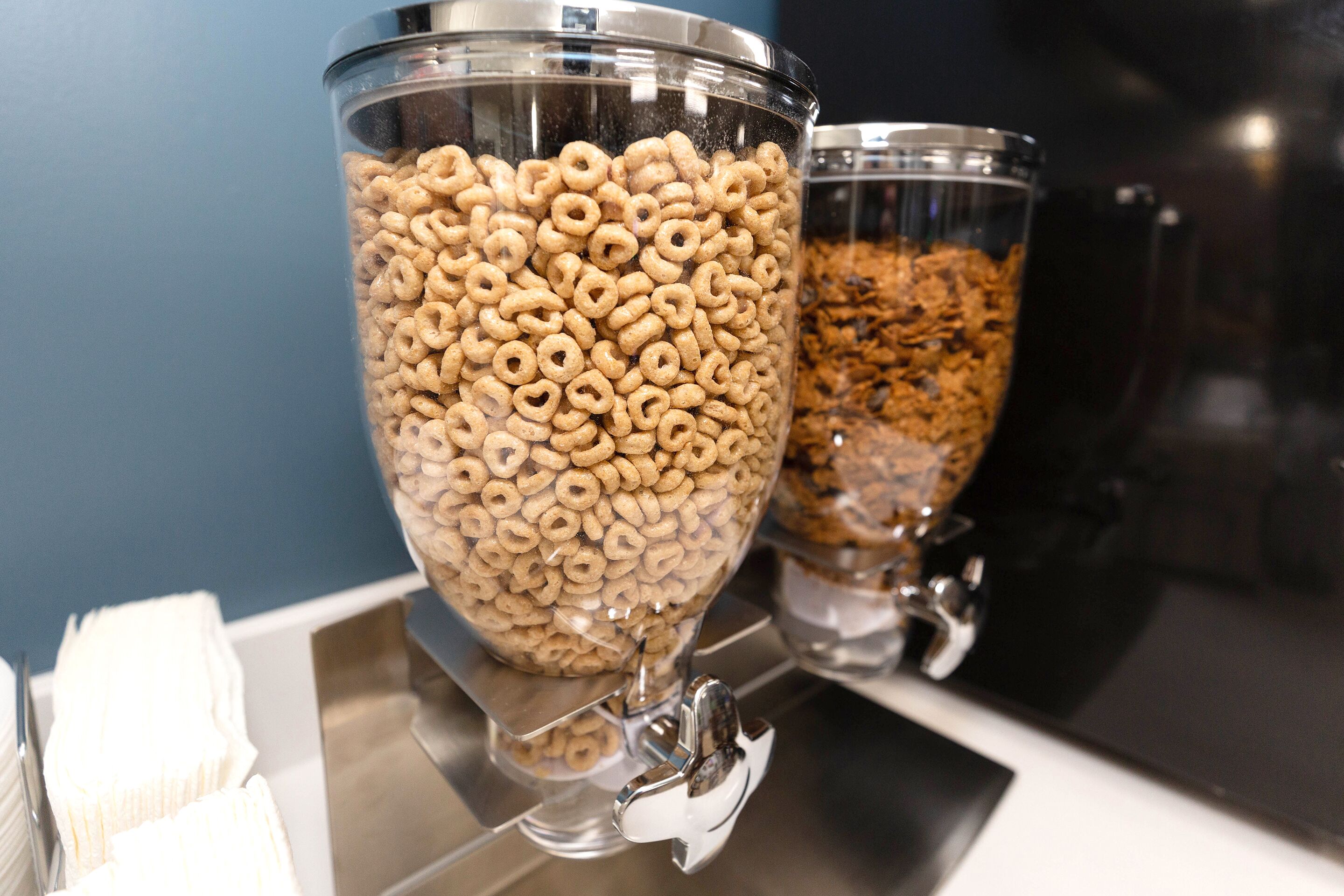 Two glass containers filled with cereal on a reflective surface.