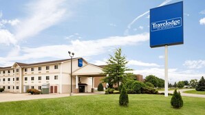 Un hotel Travelodge con un cartel grande, un acceso cubierto y un césped bien cuidado.