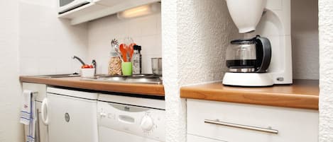 Una cocina compacta equipada con lavavajillas, microondas y cafetera.