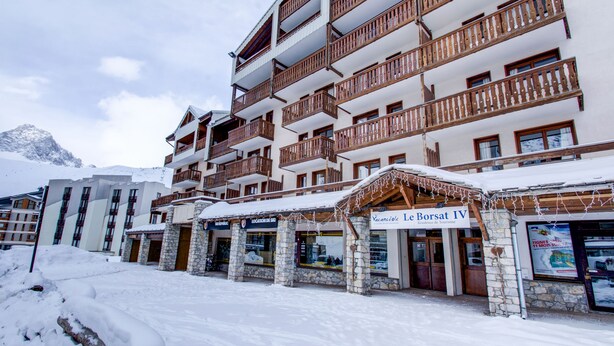 A multi-story hotel with stone facade and wooden balconies, featuring a sign for 'Le Borsat IV'. - Vacancéole - Le Borsat IV (Tignes)