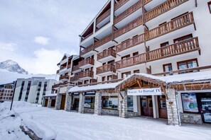 A multi-story hotel with stone facade and wooden balconies, featuring a sign for 'Le Borsat IV'. - Vacancéole - Le Borsat IV (Tignes)