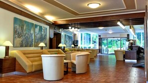 A spacious lobby with a sofa, chairs, and a reception desk. - Top Hotel Agricola (Marianske Lazne)