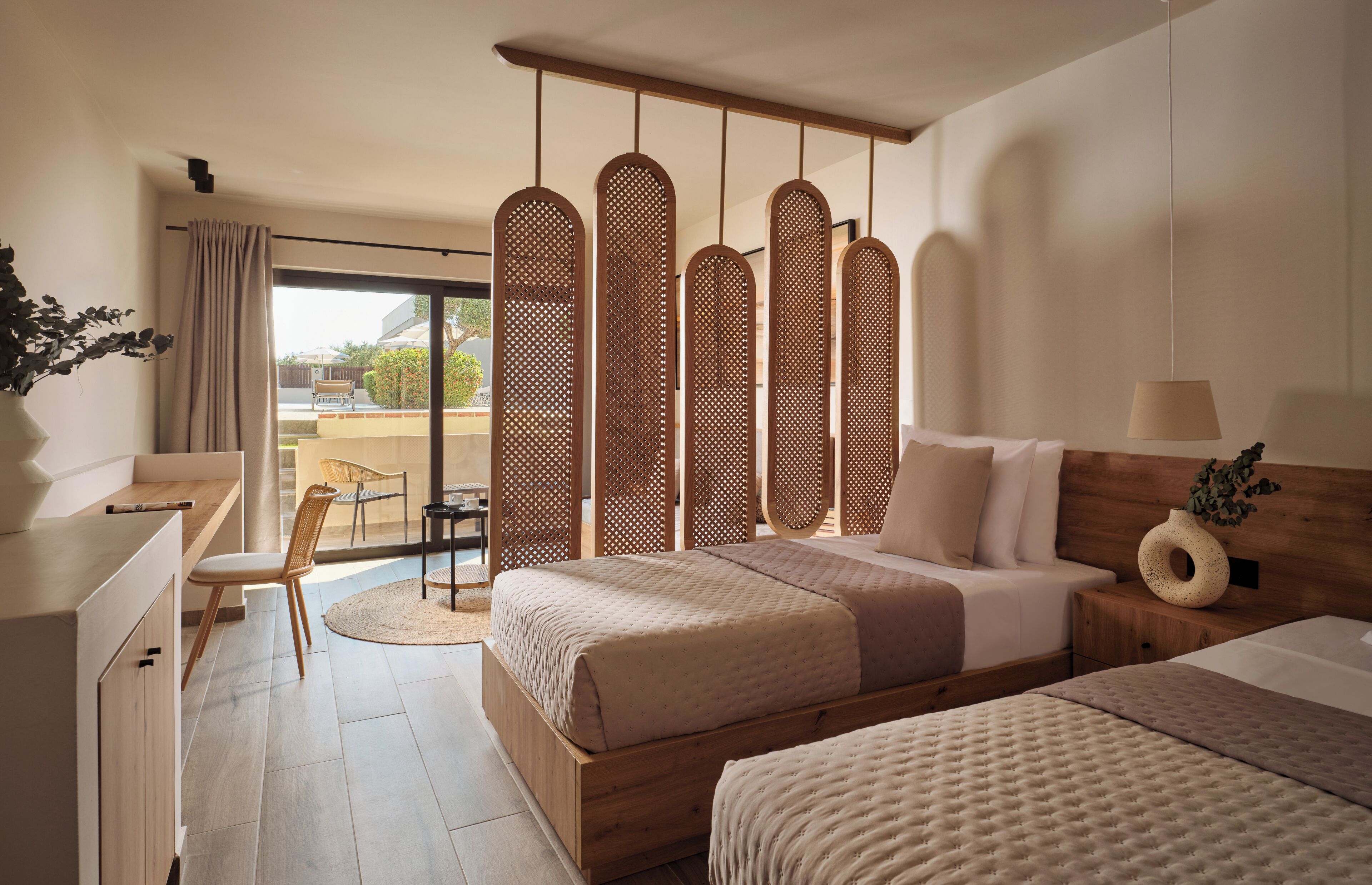 Habitación de hotel moderna con una cama grande, un escritorio y vistas al exterior.