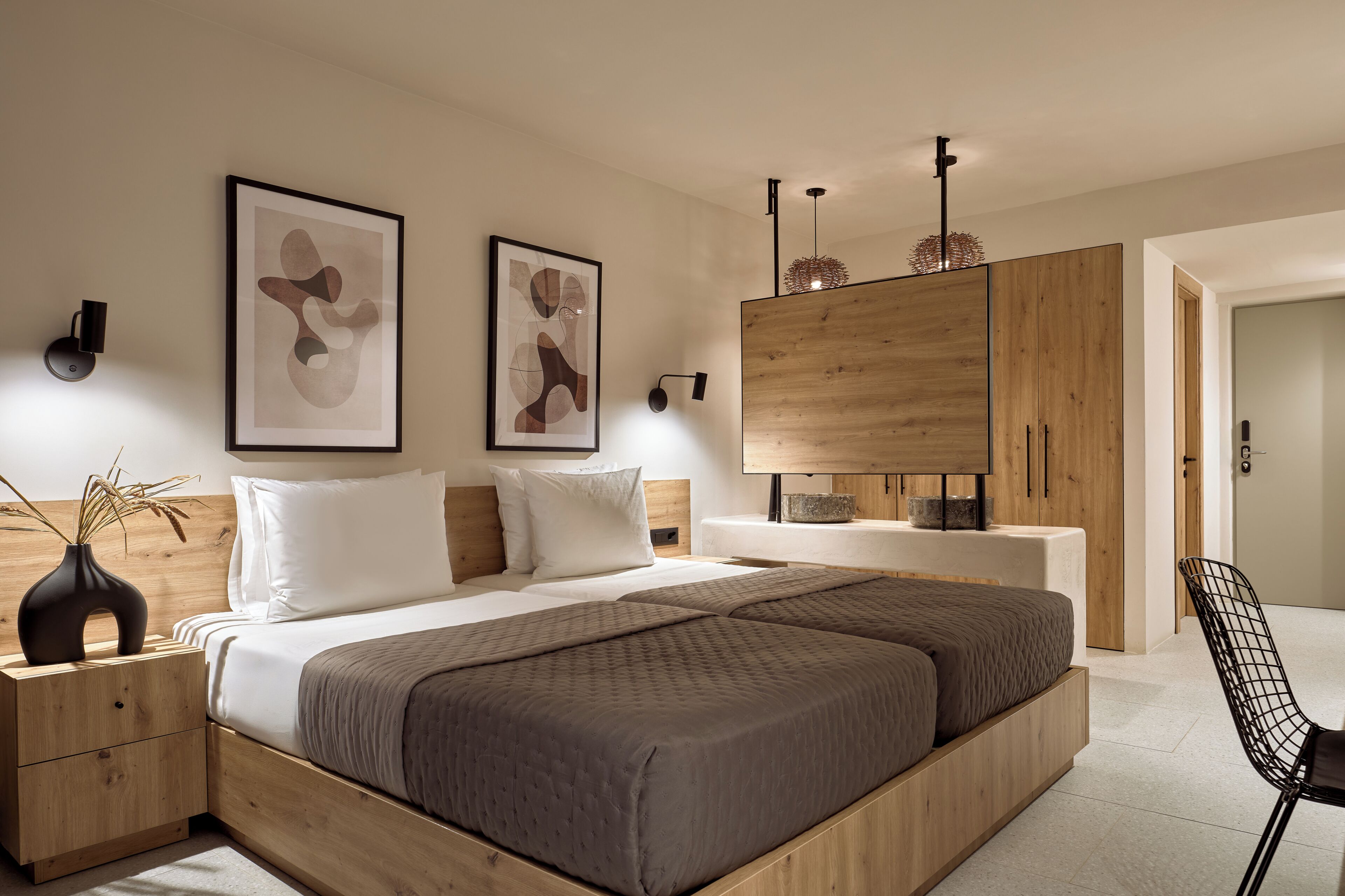 Quarto moderno com uma cama grande, cabeceira de madeira, mesas de cabeceira e um guarda-roupa.