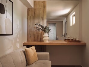 A modern interior with a wooden counter, a sofa with a patterned cushion, and a vase with greenery. - Filoxenia Hotel Zakynthos (Zakynthos)