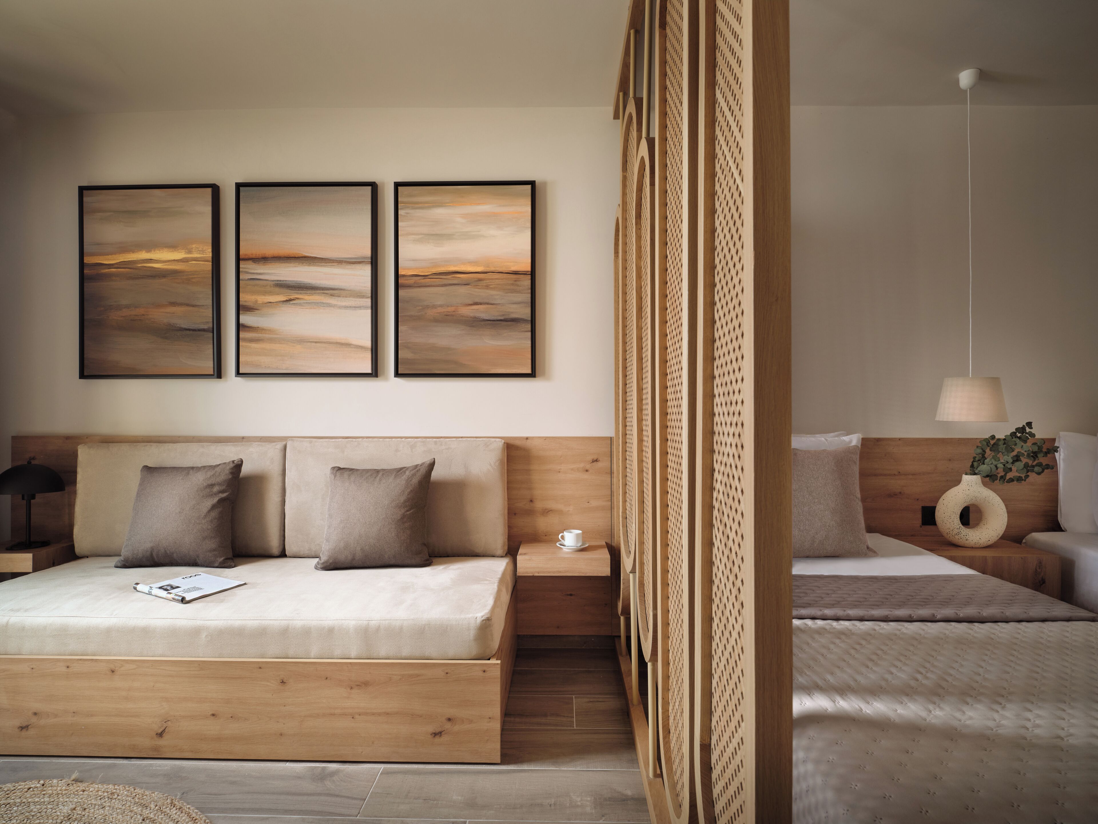 A modern bedroom with a wooden headboard, a bed with a beige mattress and pillows, a nightstand with a lamp, and a wall-mounted shelf with a vase.