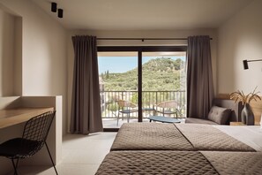 A hotel room with a bed, a desk, and a chair. There is a balcony with a view of greenery and buildings. - Filoxenia Hotel Zakynthos (Zakynthos)