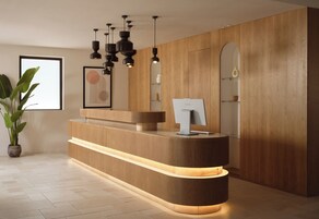 Una reception dal design moderno, con finiture in legno e illuminazione integrata.