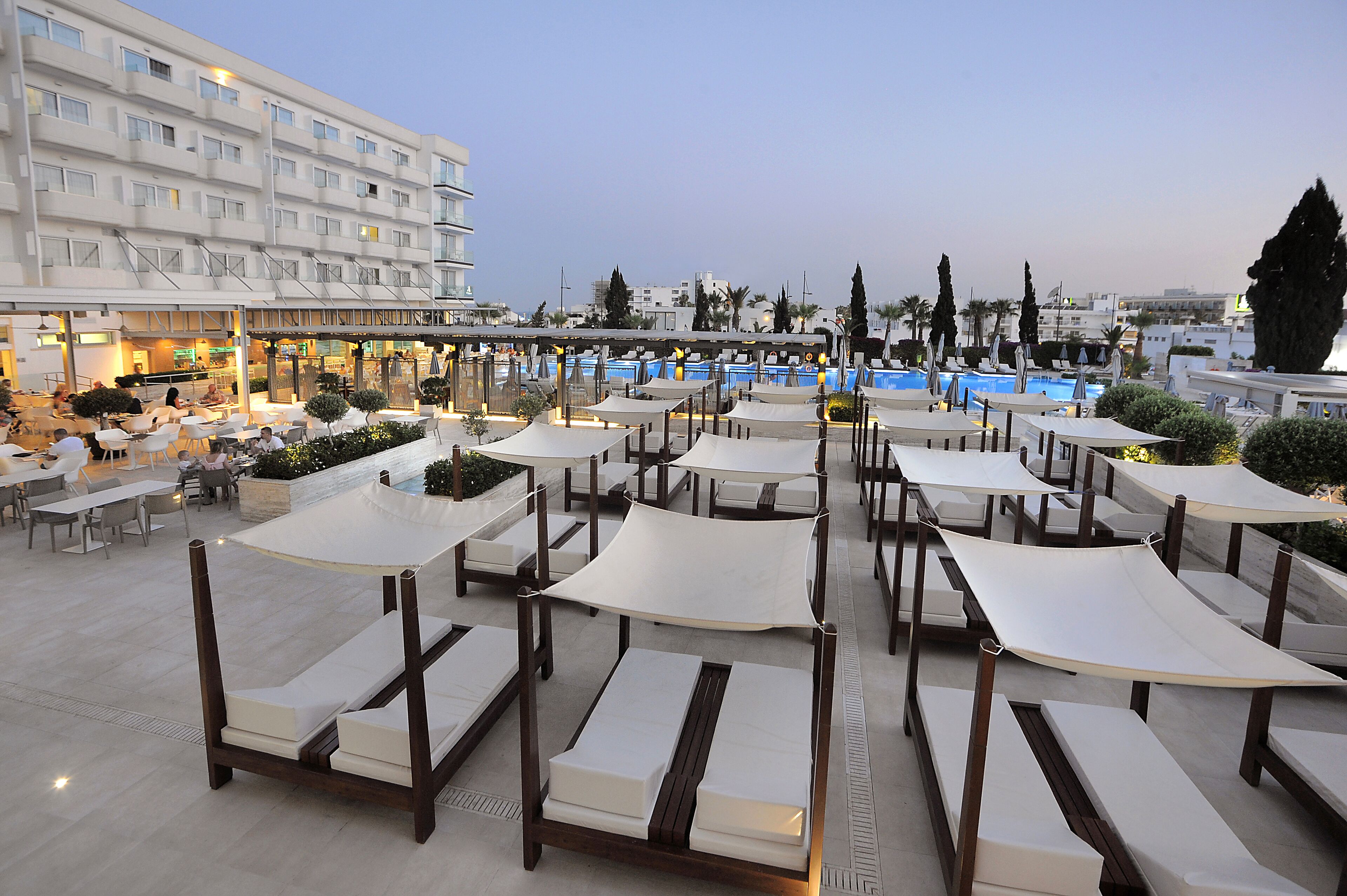 Une terrasse sur le toit dotée de plusieurs chaises longues et d’une piscine.