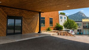 A modern building with a wooden ceiling, large windows, and a view of a mountain. - Expedition Lodge Estes Park (Estes Park)