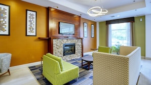A hotel lobby with a stone fireplace, framed artwork on the walls, and modern seating. - Holiday Inn Express La Plata by IHG (La Plata)