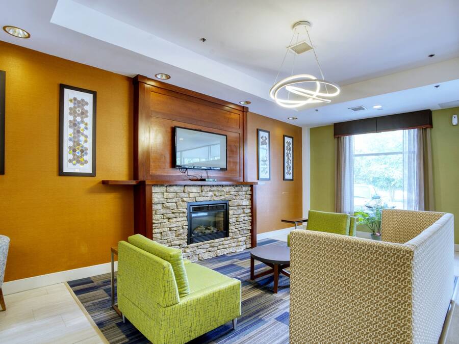 A hotel lobby with a stone fireplace, framed artwork on the walls, and modern seating.