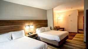 A hotel room with two beds, a wooden headboard, bedside lamps, a nightstand, and a carpeted floor. - Holiday Inn Express La Plata by IHG (La Plata)