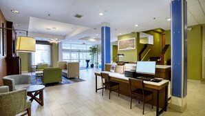 A modern hotel lobby with a reception desk, seating area, and a staircase. - Holiday Inn Express La Plata by IHG (La Plata)