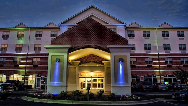 A hotel entrance with a brick facade, large windows, and a central archway. - Holiday Inn Express La Plata by IHG (La Plata)