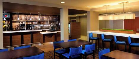 A modern hotel lobby with a bar area, seating arrangements, and a reception desk.