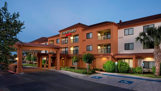 Un hotel Courtyard by Marriott con entrada cubierta, varios balcones y un estacionamiento con acceso para discapacitados.