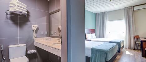 A modern bathroom with a toilet, sink, and towel rack.