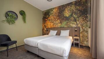 A bedroom with a bed, a chair, a small stool, and a wall with a nature-themed mural.