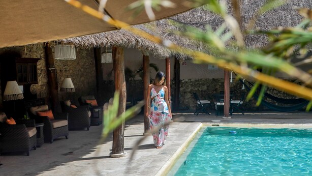 A poolside area with lounge chairs and a thatched roof structure. - Casa Lucia Hotel Boutique (Mérida)