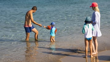 På stranden, solstolar, parasoller och strandhanddukar