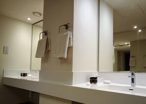A modern bathroom with a large mirror, two towel racks, a white countertop, and a sink. - Venus Beach Hotel (Paphos)