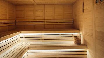 A sauna with wooden benches and a bucket.