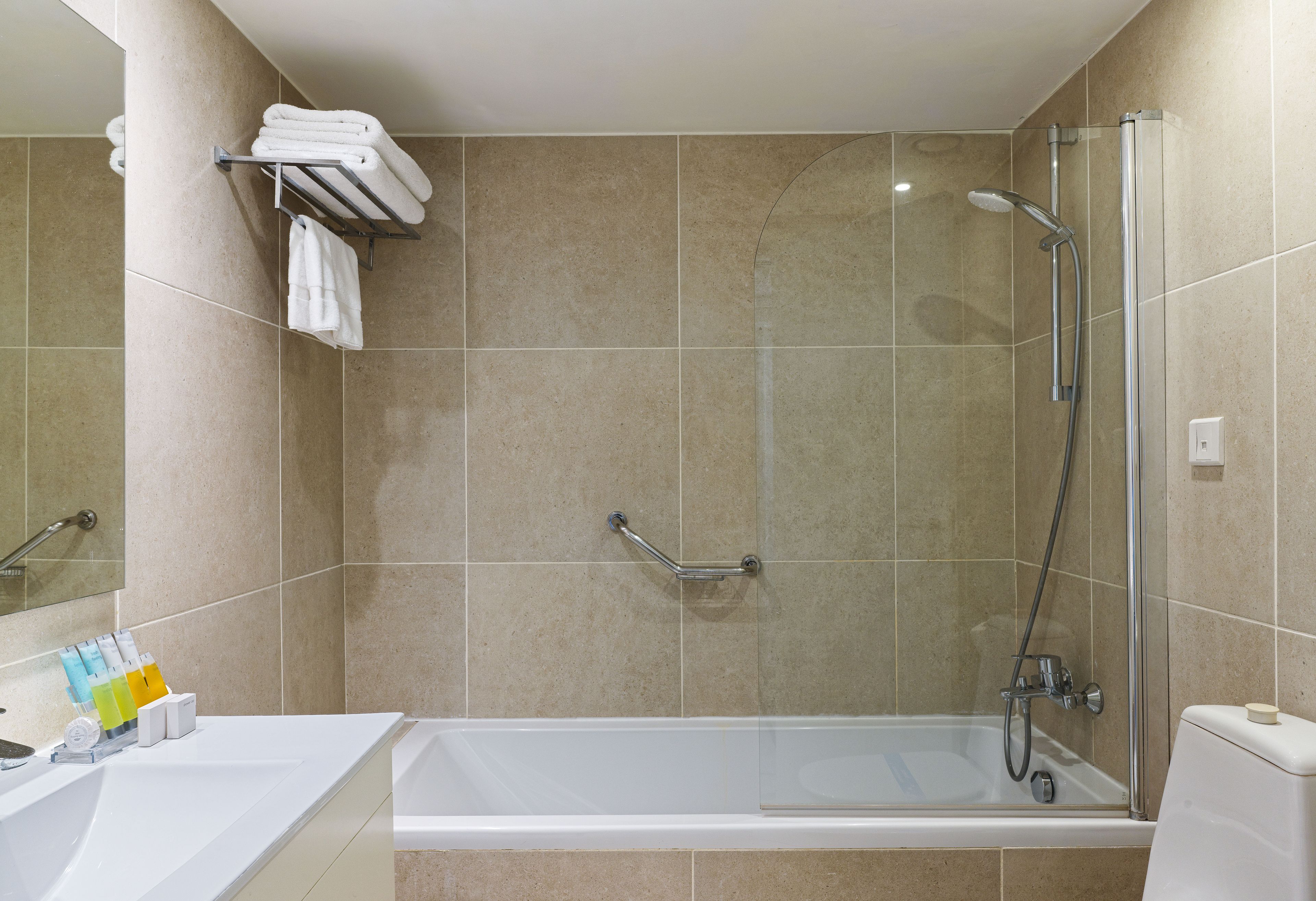 A bathroom with a bathtub, a shower, and a towel rack.