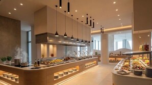A modern kitchen with a central island, pendant lighting, and a buffet setup. - Venus Beach Hotel (Paphos)