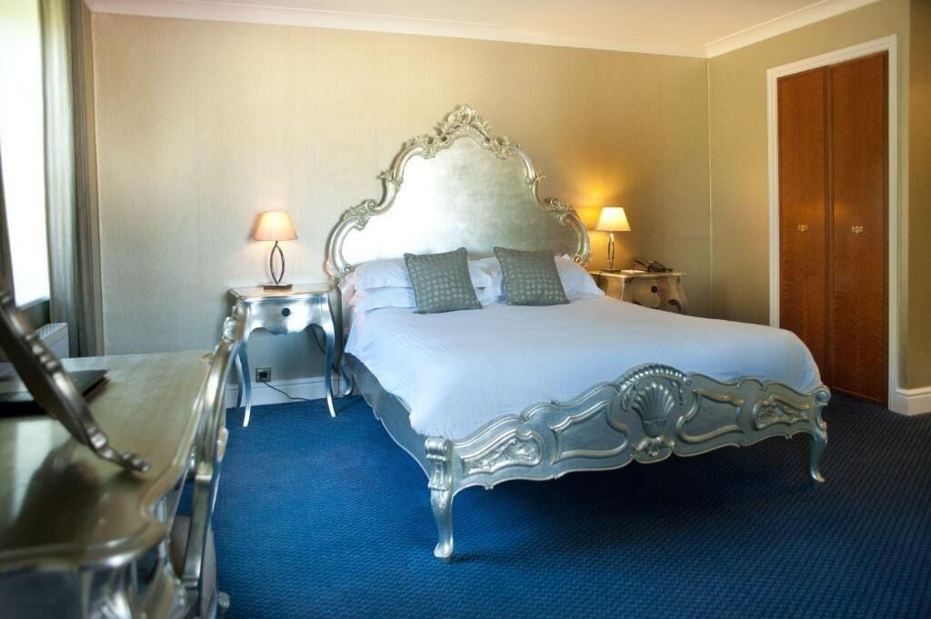Una camera d'albergo con un letto grande, due comodini e un armadio.