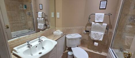 A bathroom with a sink, toilet, and shower.