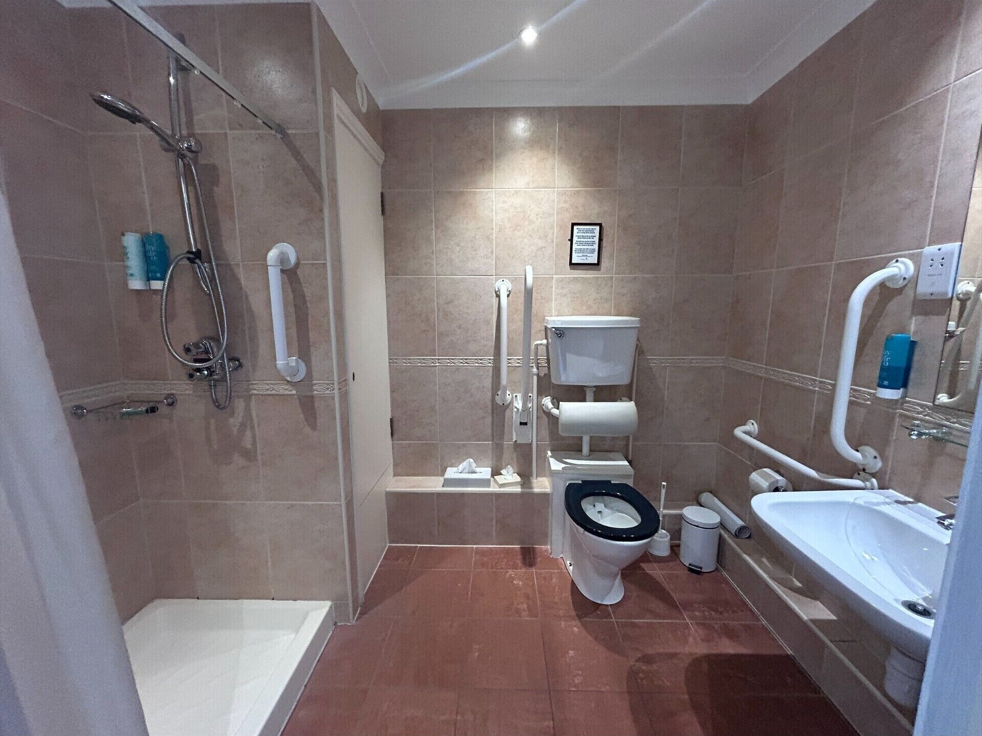 A modern bathroom with a shower, toilet, and sink.