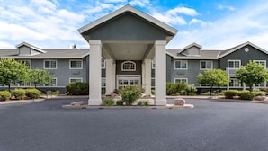 A modern hotel with a central entrance pavilion, multiple windows, and landscaped surroundings. - Best Western Rose Quartz Inn (Chester)