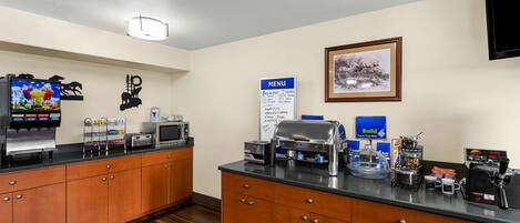 A self-service breakfast area with a coffee machine, toaster, and beverage dispenser.