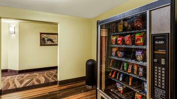 A vending machine with snacks and drinks in a hotel hallway.